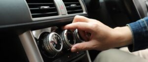 Ruletas de calefacción del coche que no funcionan, mientras una mano intenta girarlas
