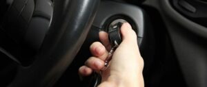 Mujer haciendo un intento de arrancar el coche para que se active el conmutador de arranque