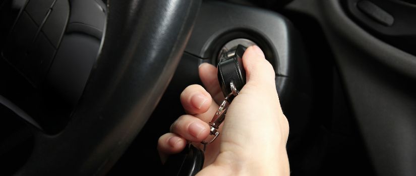 Mujer haciendo un intento de arrancar el coche para que se active el conmutador de arranque